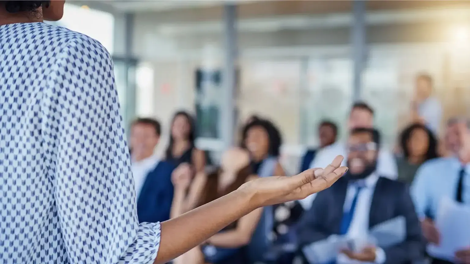 Woman giving a business presentation to an audience in a modern conference room